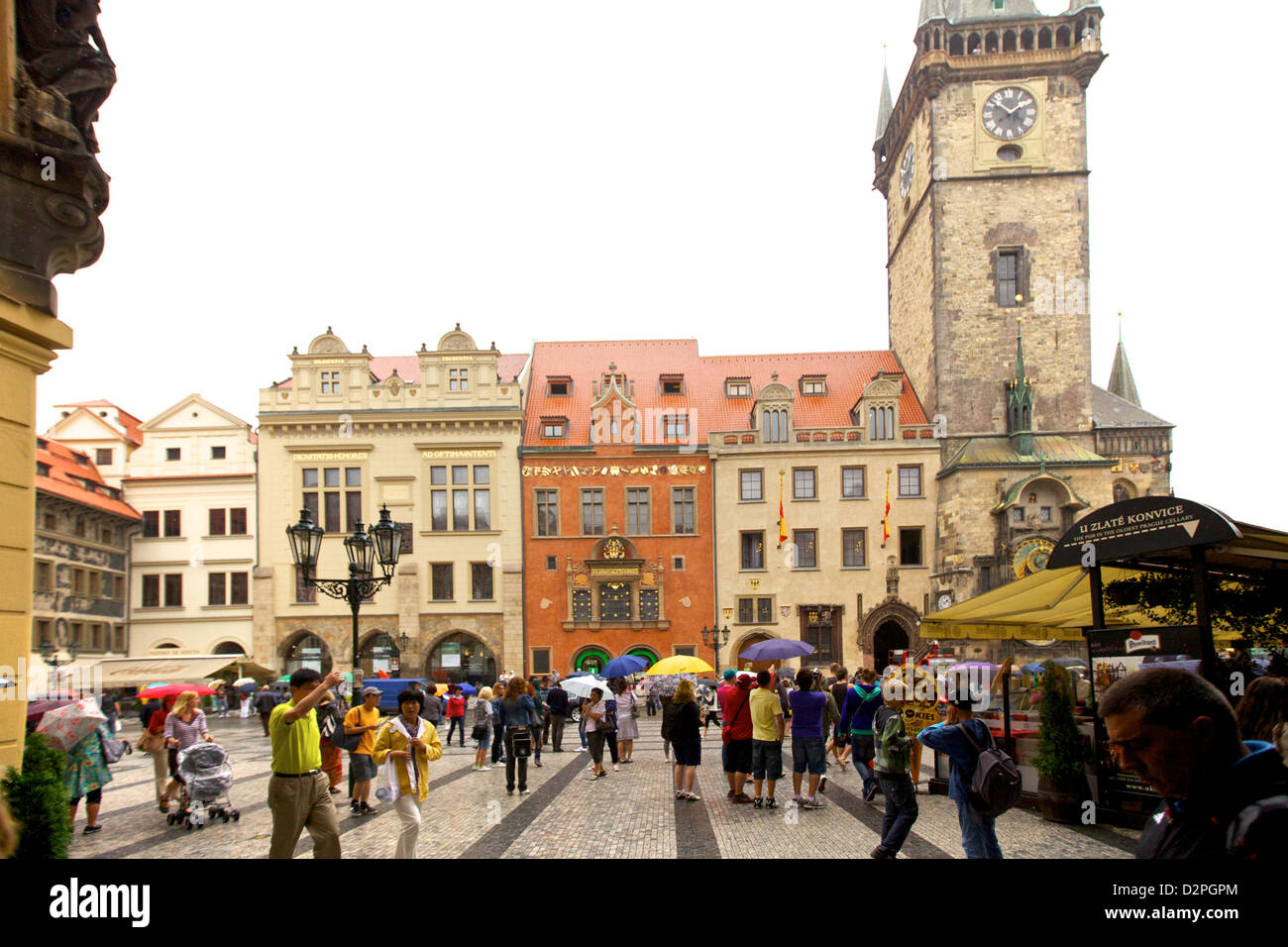I turisti esplorano la vivace Piazza della città Vecchia di Praga, circondata da edifici colorati, l'Orologio Astronomico e lo storico Municipio della città Vecchia sotto An Foto Stock