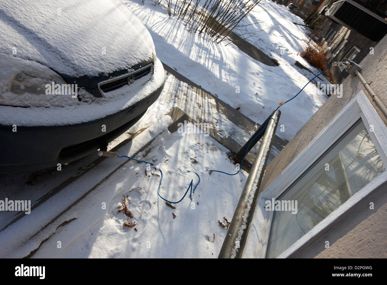 Alimentazione esterna uscita collegata al riscaldatore per il monoblocco del motore di frozen auto al di fuori del palazzo in Saskatoon Saskatchewan Canada Foto Stock