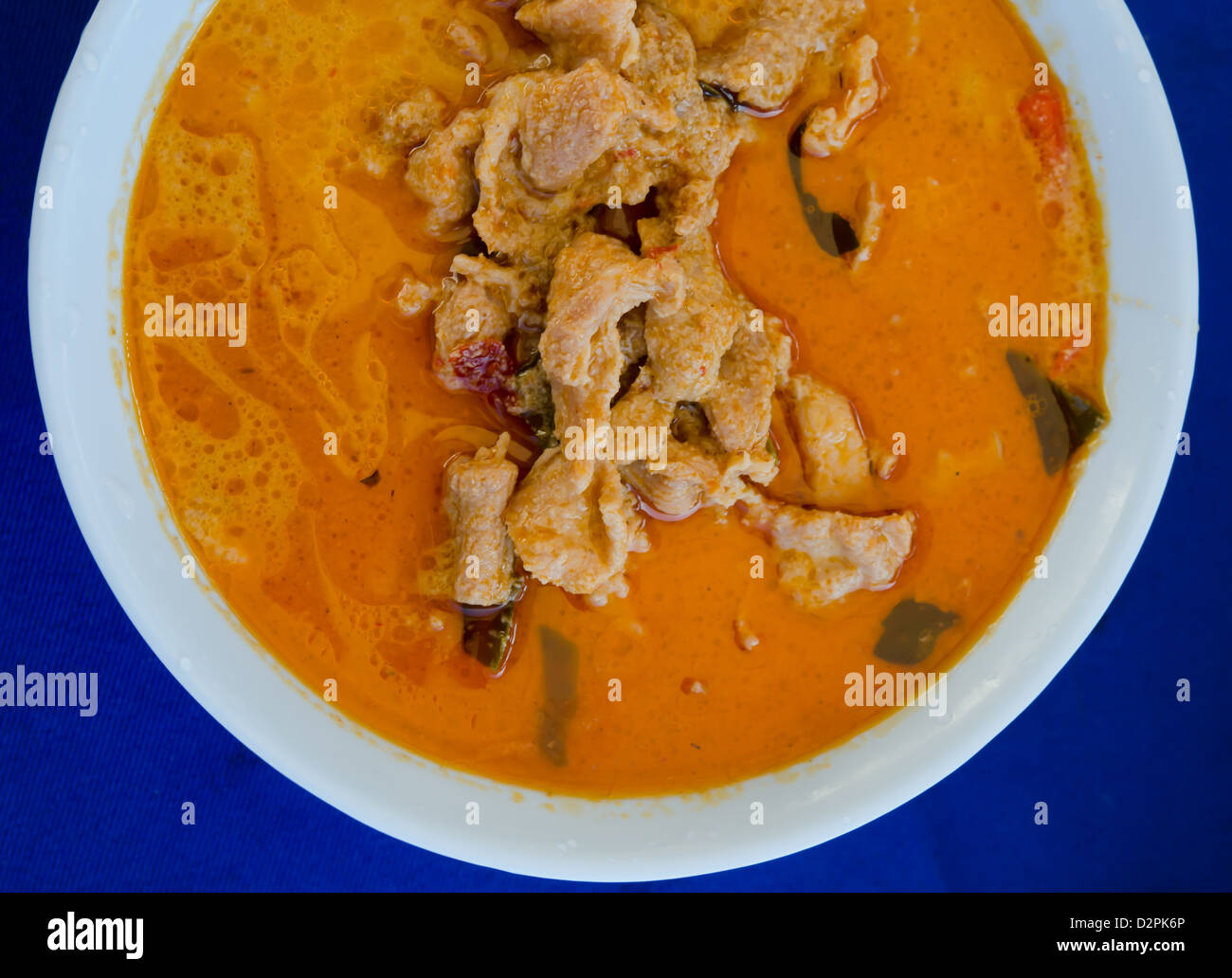 Vista da sopra la carne di maiale in massa di arachidi Crema di Cocco curry su sfondo blu Foto Stock