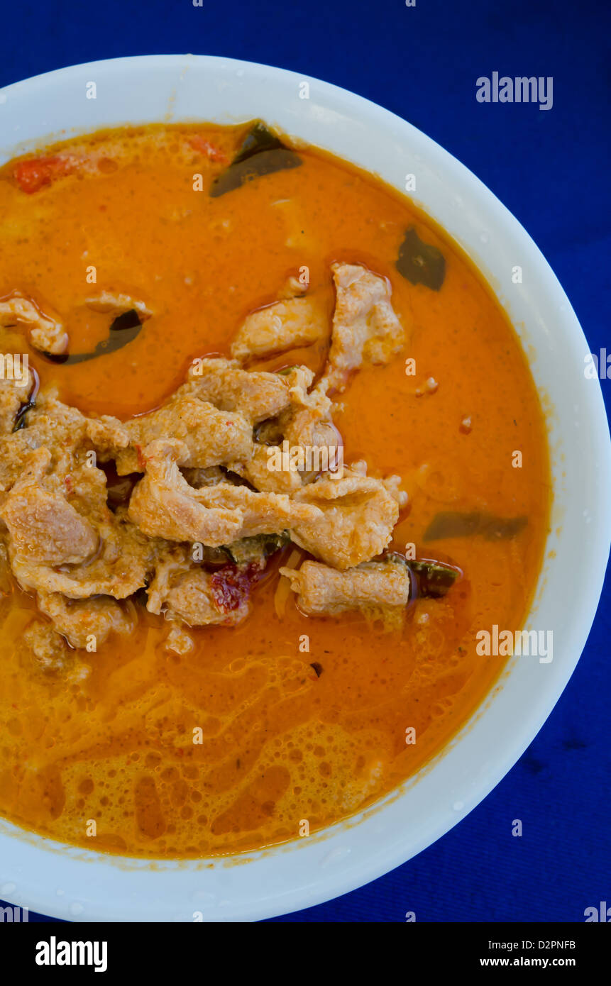 Vista da sopra la carne di maiale in massa di arachidi Crema di Cocco curry su sfondo blu Foto Stock