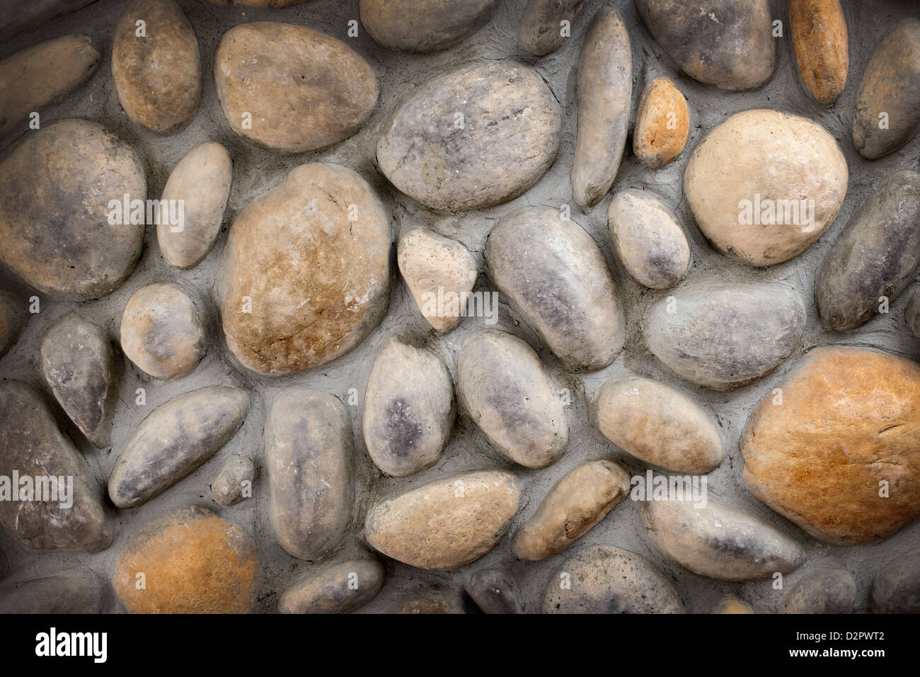 Muro di pietre e sassi in background di cemento Foto Stock