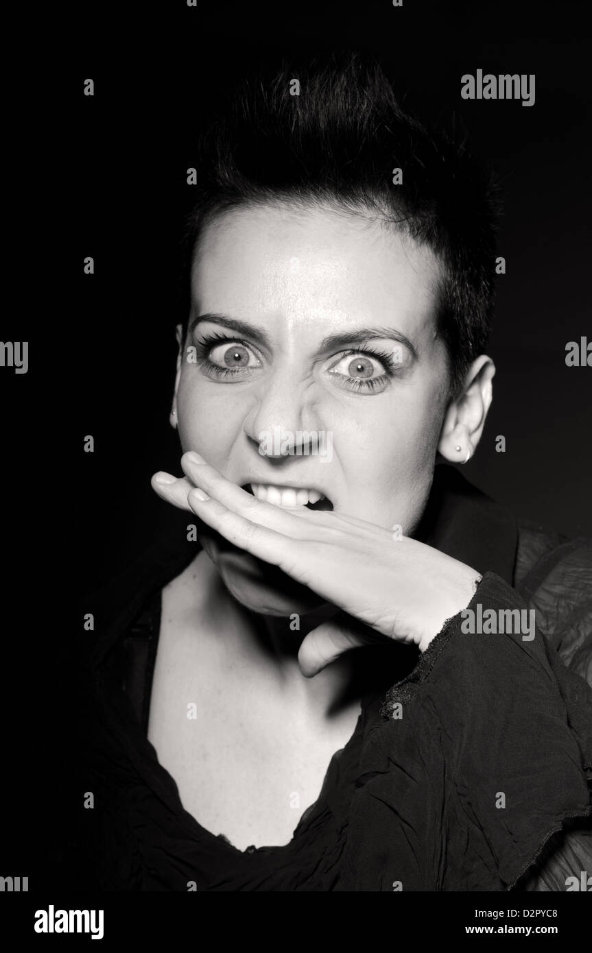 Real giovane donna di mordere la mano Foto Stock