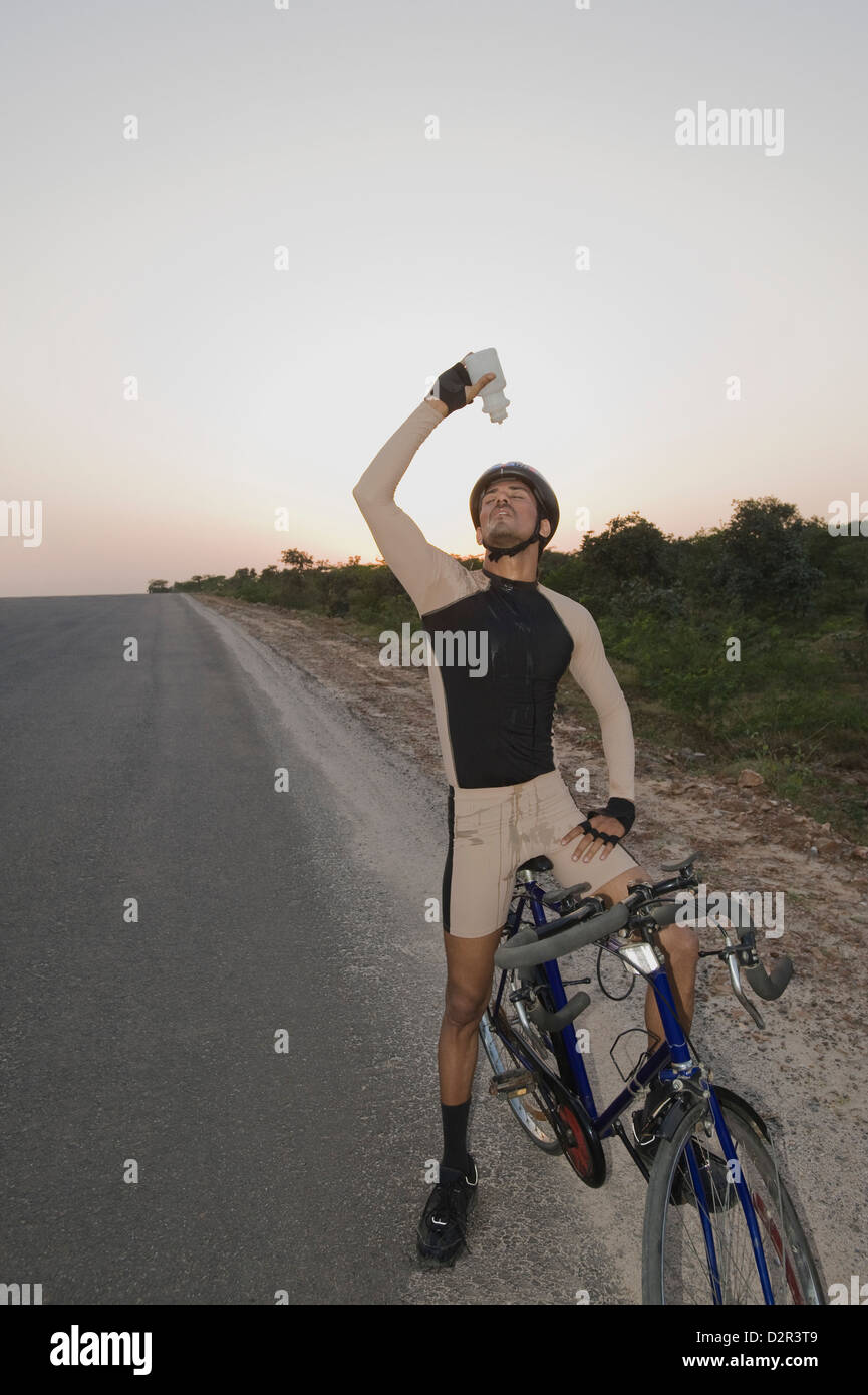 Ciclista versando acqua su se stesso Foto Stock