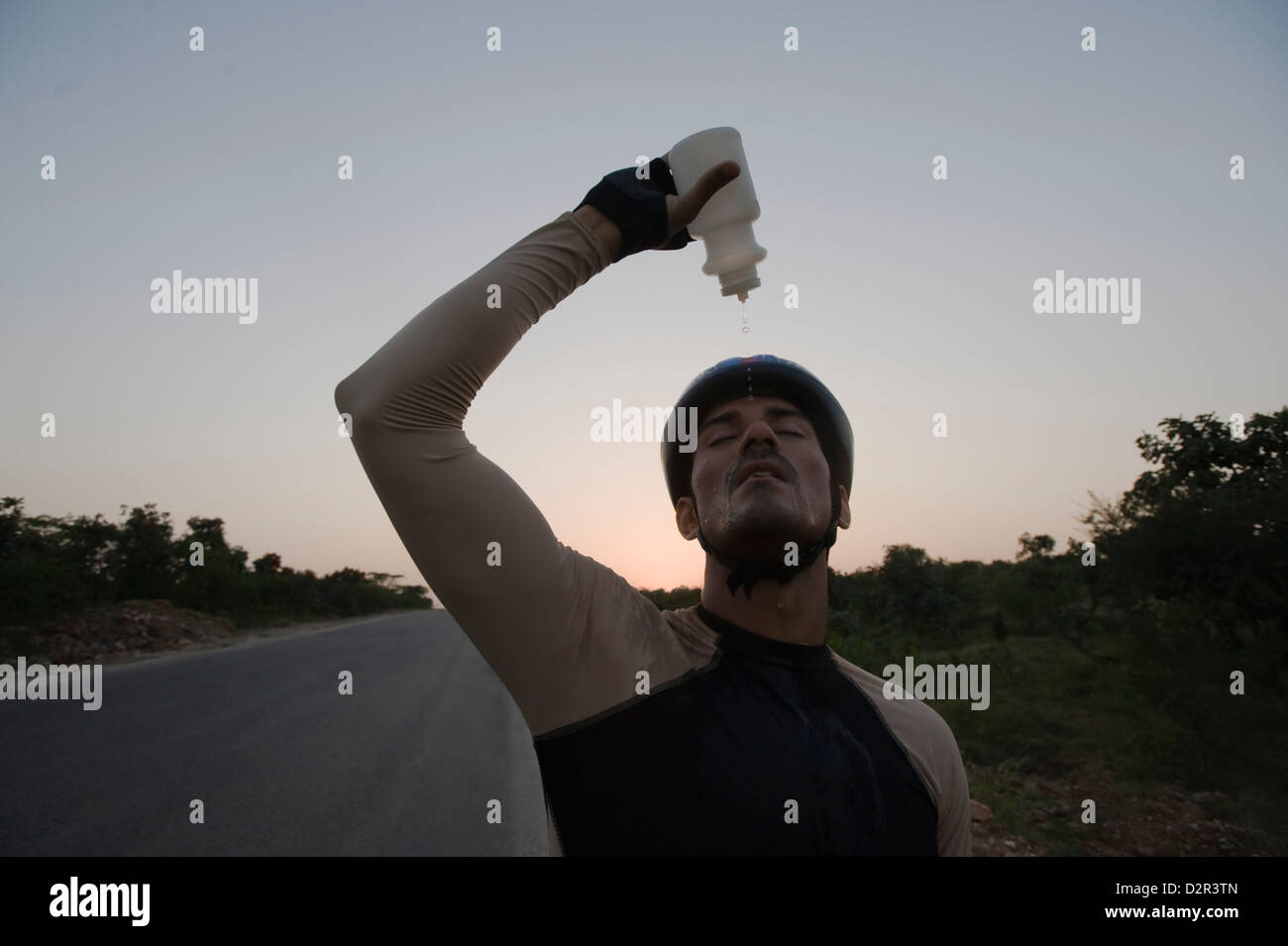 Ciclista versando acqua su se stesso Foto Stock