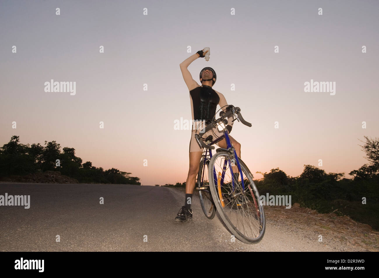 Ciclista versando acqua su se stesso Foto Stock