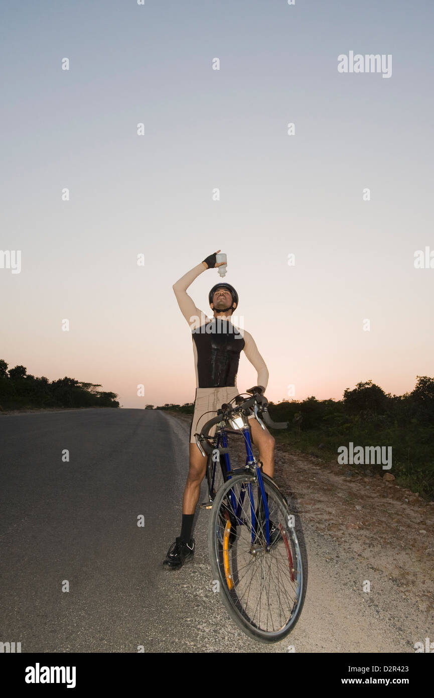 Ciclista versando acqua su se stesso Foto Stock