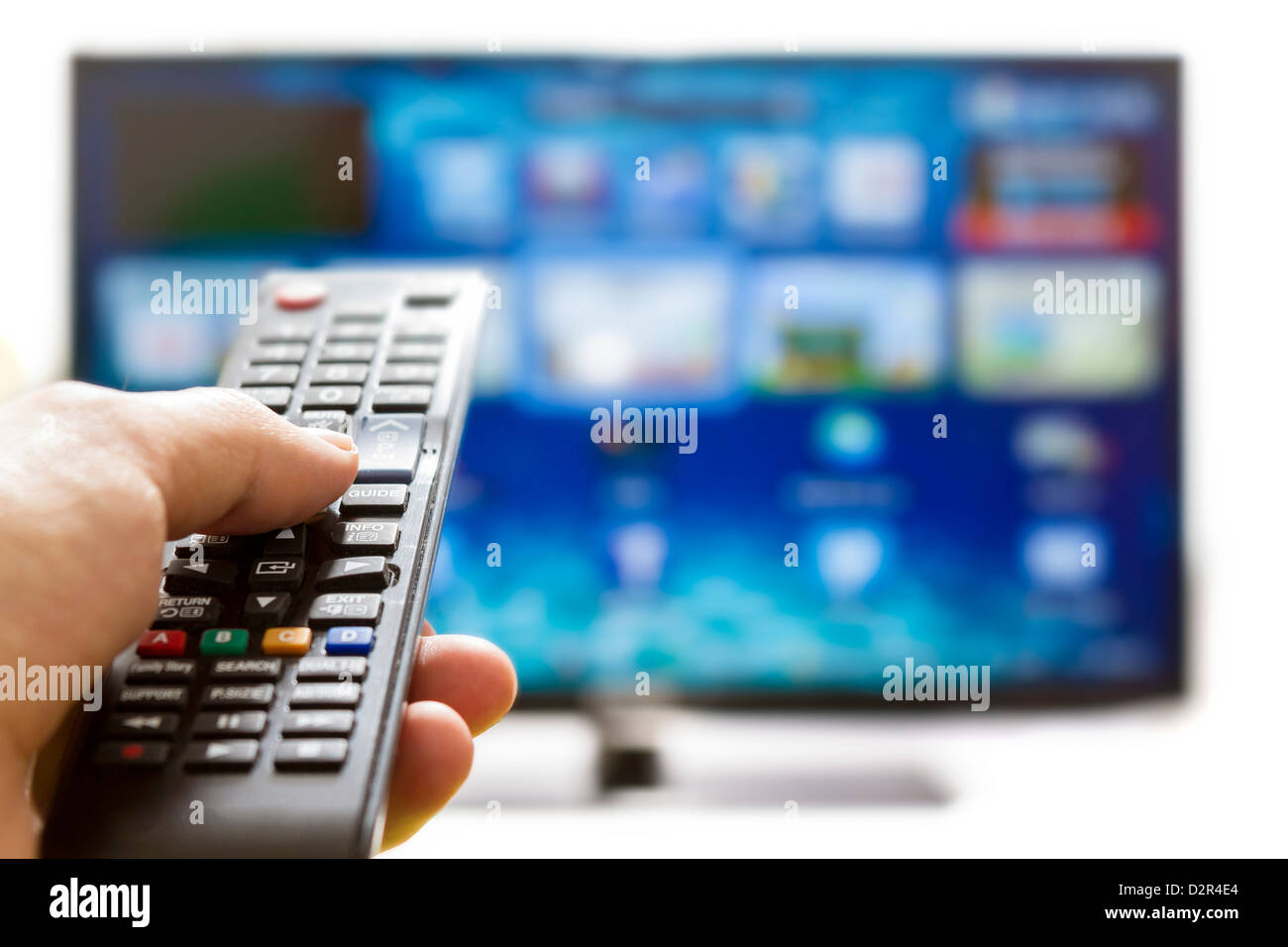 Telecomando per la TV cambia i canali il pollice sul blu sullo schermo TV Foto Stock