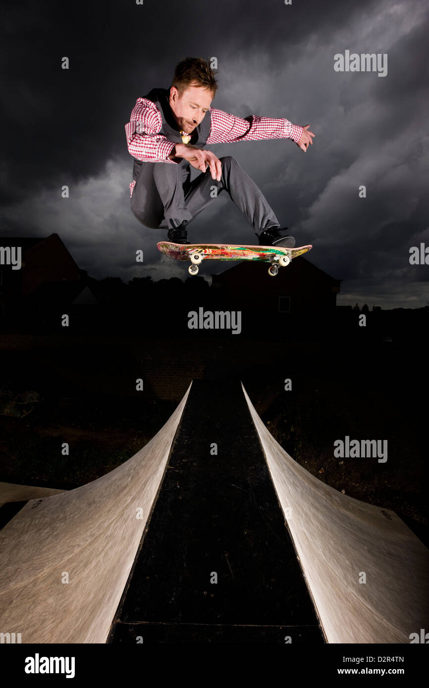 Imprenditore rischiare di saltare sopra la rampa di skate Foto Stock