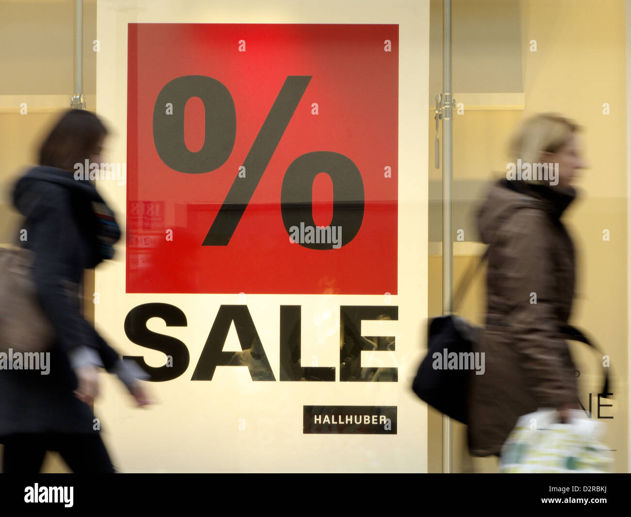 I passanti dei consumatori passando uno sconto vendita segno Foto Stock