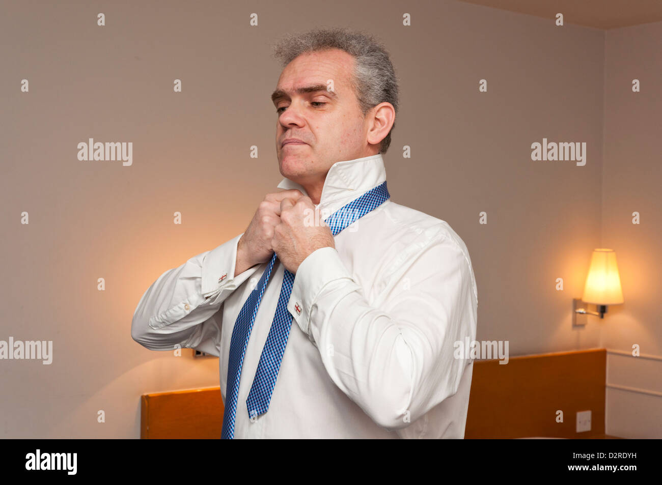 Persone di mezza età business man medicazione in una camera di hotel. Foto Stock