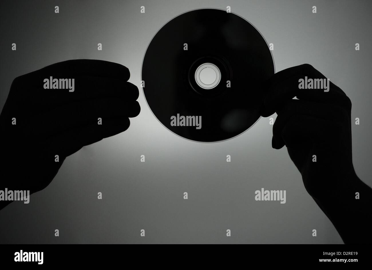 La figura mostra una silhouette di due mani di sostituzione di un CD a Berlino, Germania, 8 gennaio 2013. Foto: Jan-Philipp Strobel Foto Stock