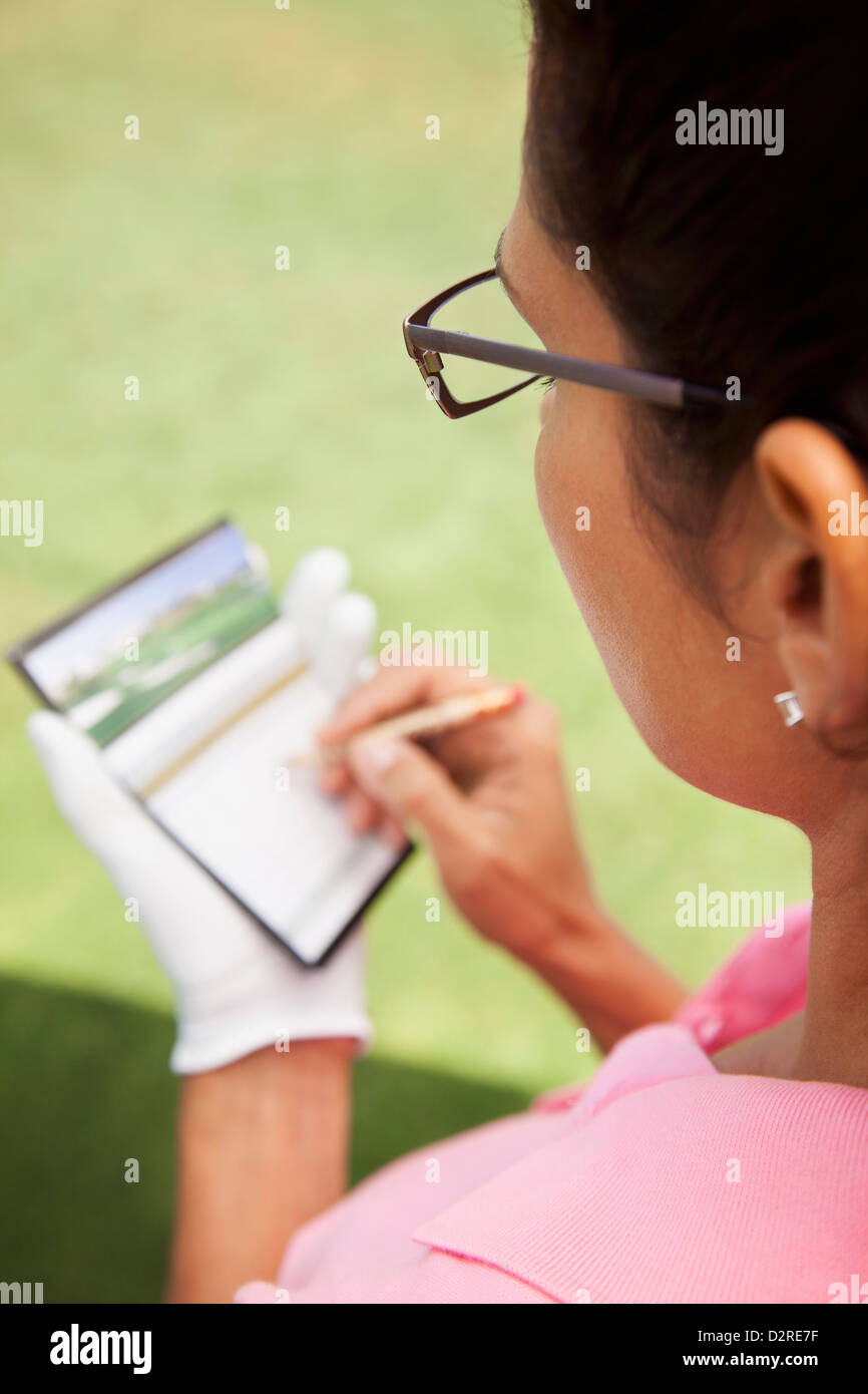 Donna tenere il punteggio durante il gioco di golf Foto Stock