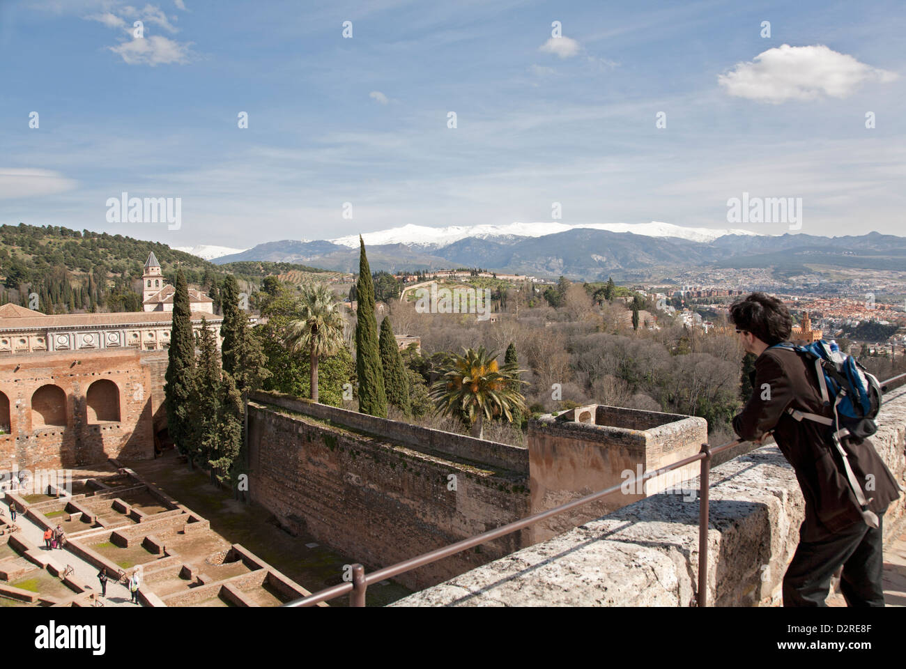 Un visitatore ammira la vista dalla Torre de la Vela del vecchio Alcazaba nell'Alhambra e il circostante paesaggio spagnolo. Foto Stock