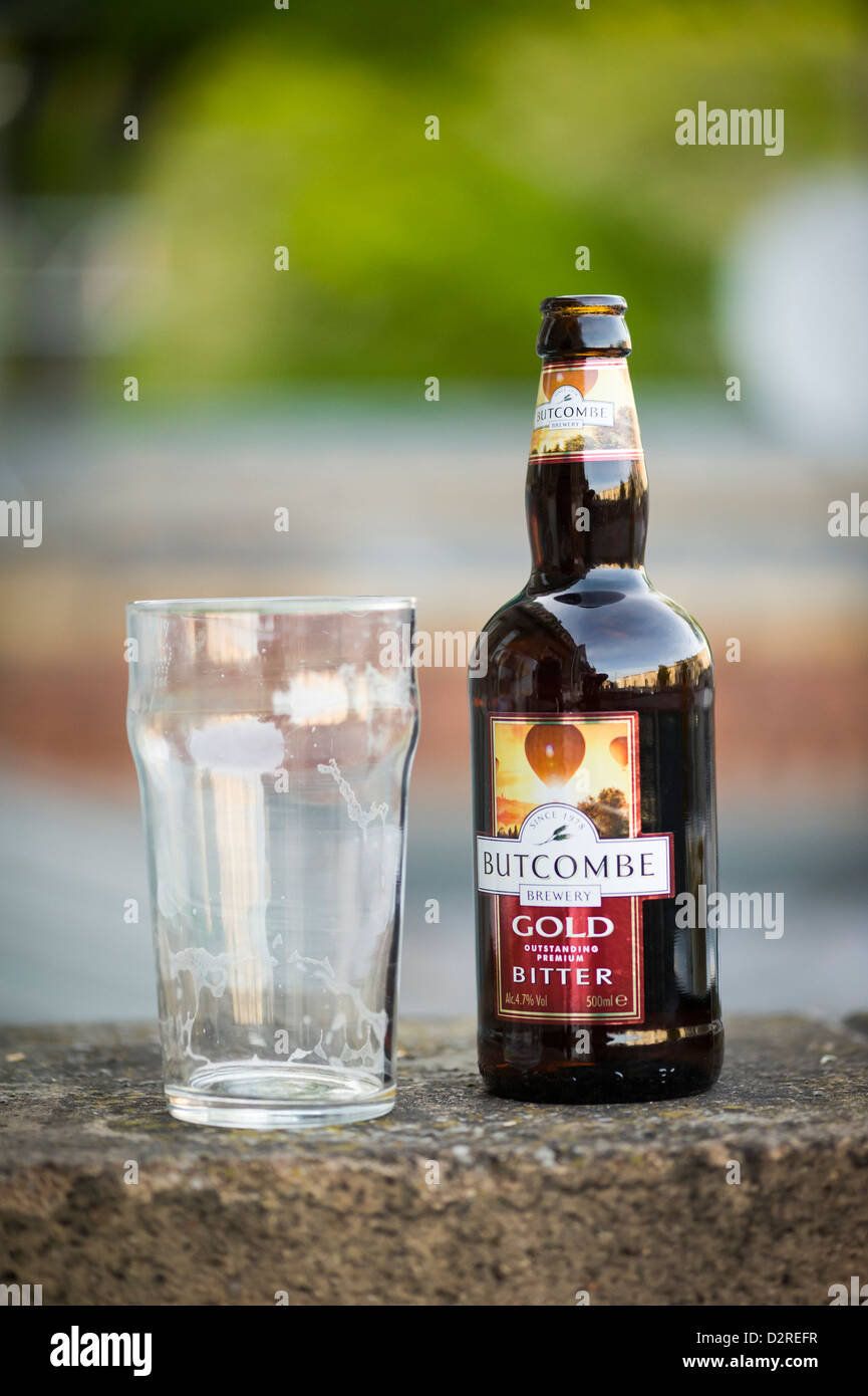La pinta bicchiere vicino ad una bottiglia di vetro di Butcombe amaro Foto Stock