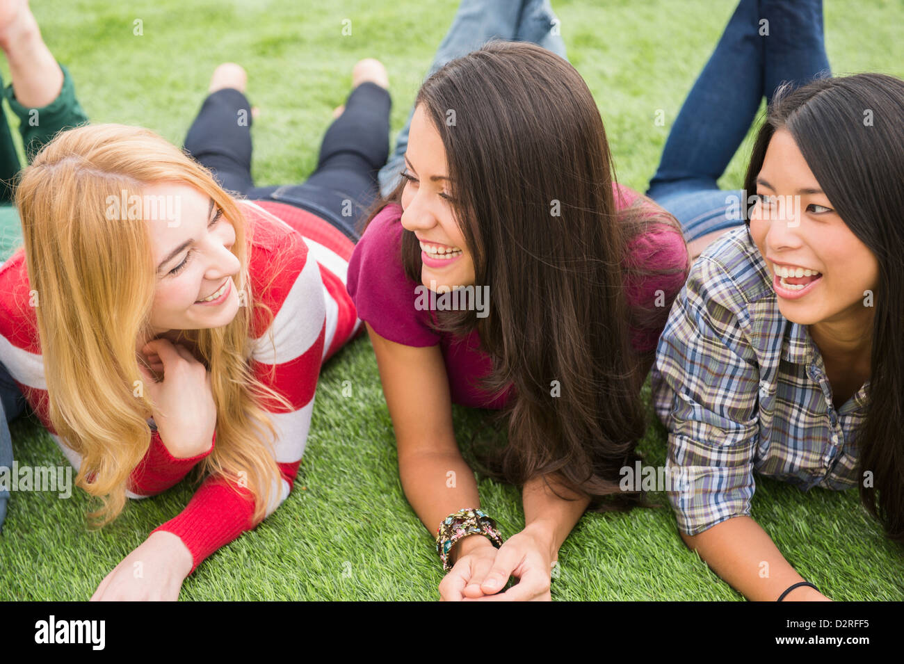Donna sorridente posa in erba insieme Foto Stock