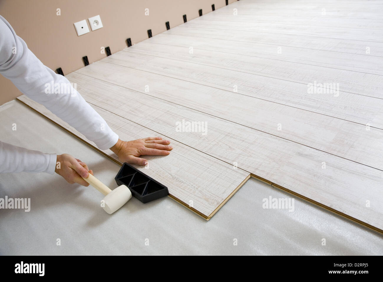 Lavoratore la posa in opera di un pavimento con pavimenti in laminato boards Foto Stock