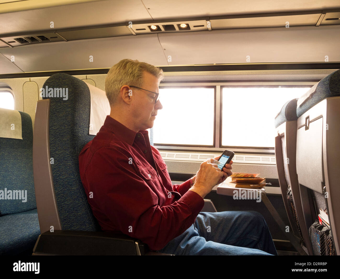 Coppia passeggero utilizzando uno smartphone sul Treno Amtrak, STATI UNITI D'AMERICA Foto Stock