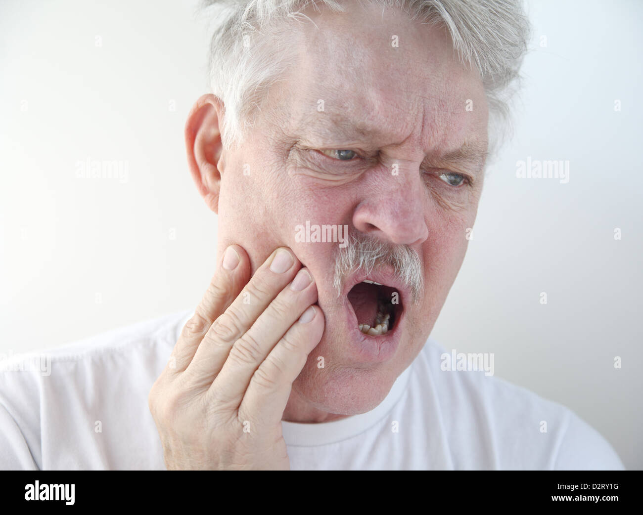Senior con man mano sulla sua guancia doloroso Foto Stock