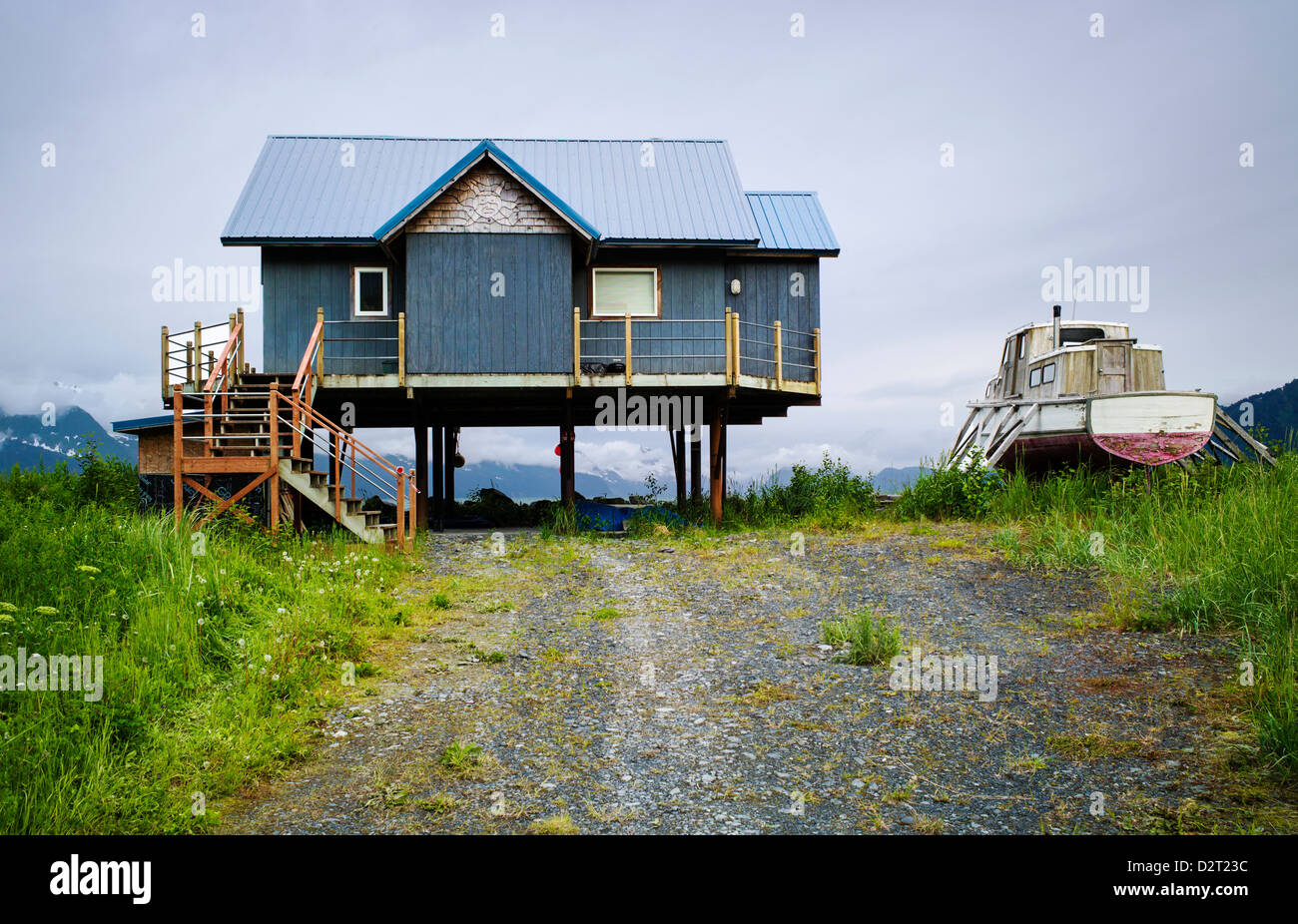 Casa e barca da pesca su palafitte lungo la spiaggia, risurrezione Bay, Seward, Alaska, STATI UNITI D'AMERICA Foto Stock