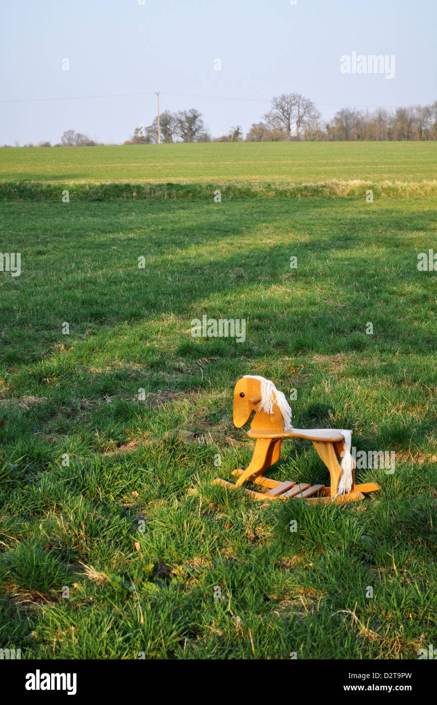 In legno cavallo a dondolo giocattolo in un campo verde Foto Stock