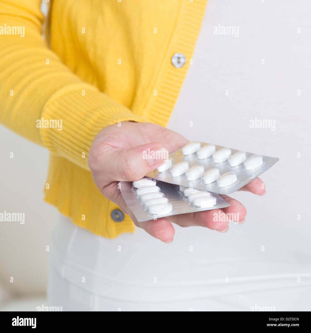 Supplementi materna. Asian donna incinta mano pillole / compresse medicina a casa. Foto Stock