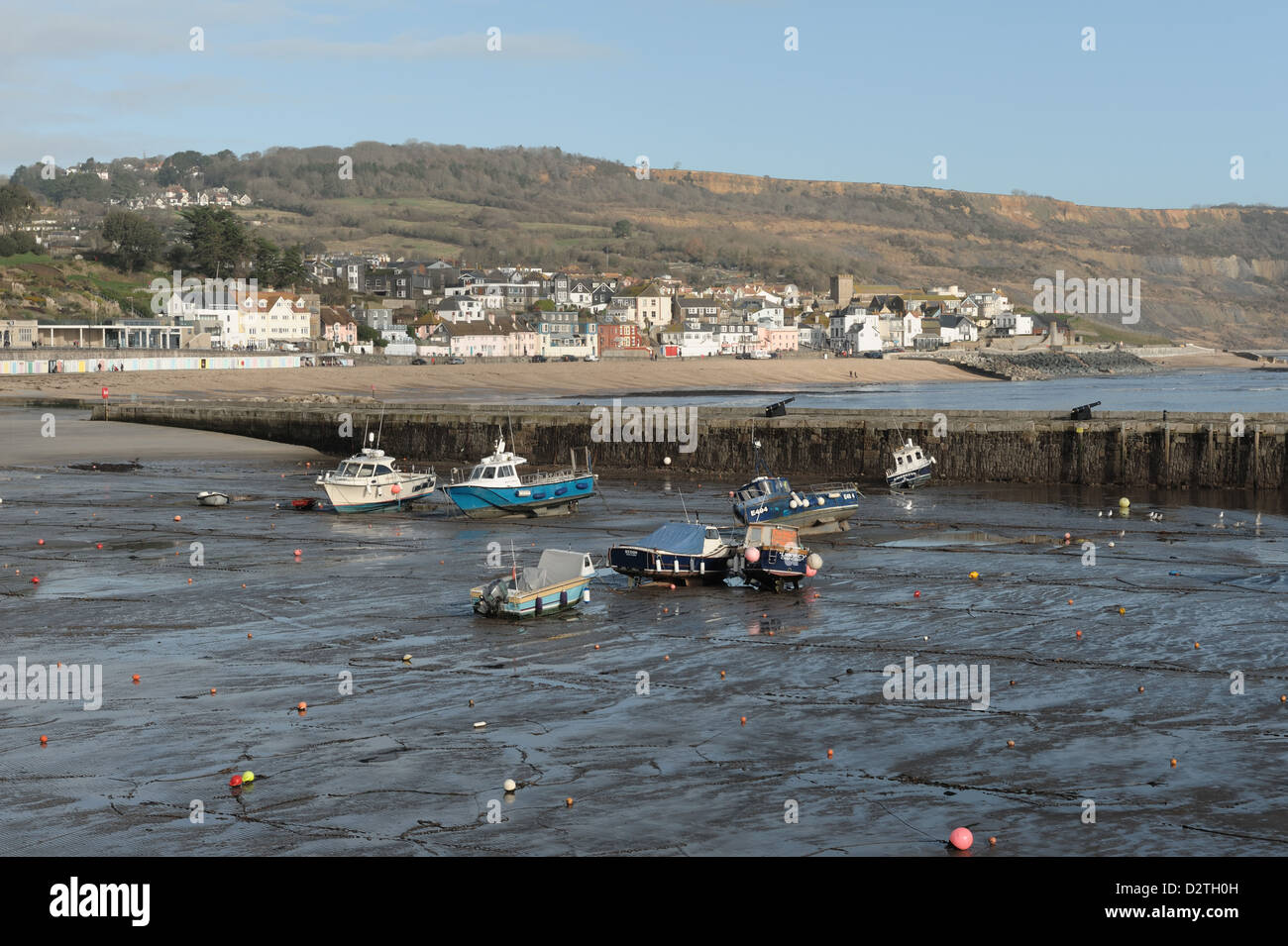 Lyme Regis harbour a bassa marea in inverno dalla Cobb, con la città e la spiaggia al di là Foto Stock