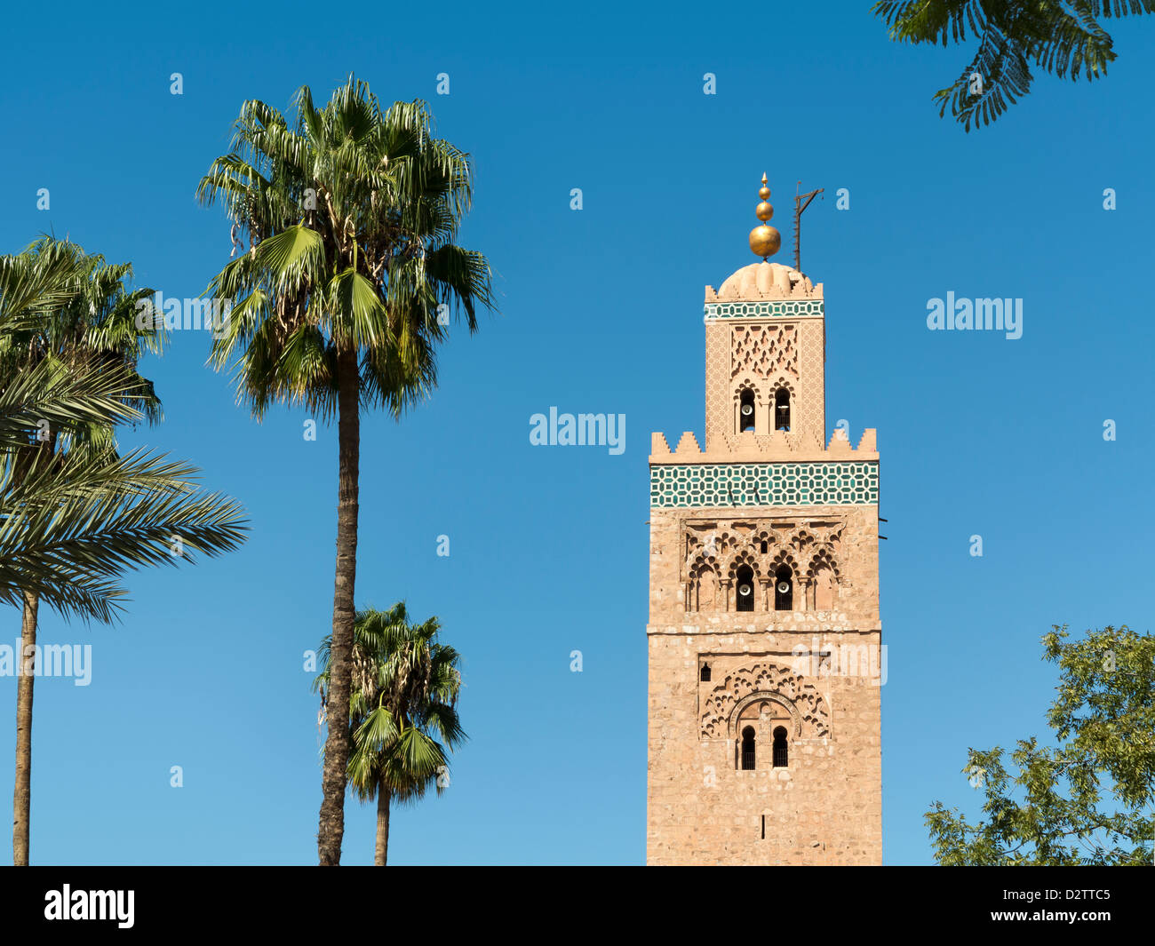 Minareto della Moschea di Koutoubia visto contro il blu intenso del cielo e palme, Marrakech, Marocco, Africa del Nord Foto Stock