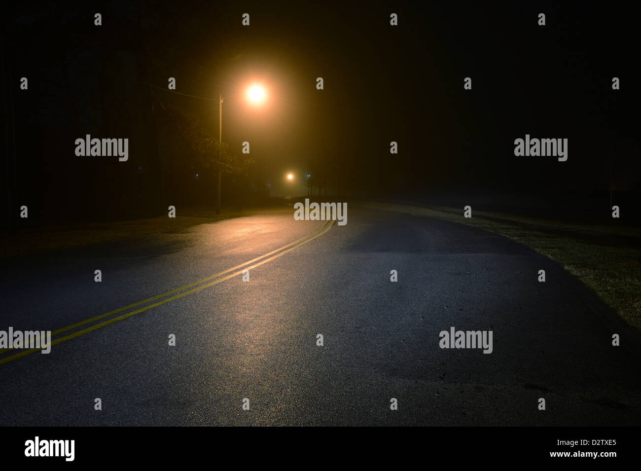 Lonely rurale strada bagnata di notte Foto Stock