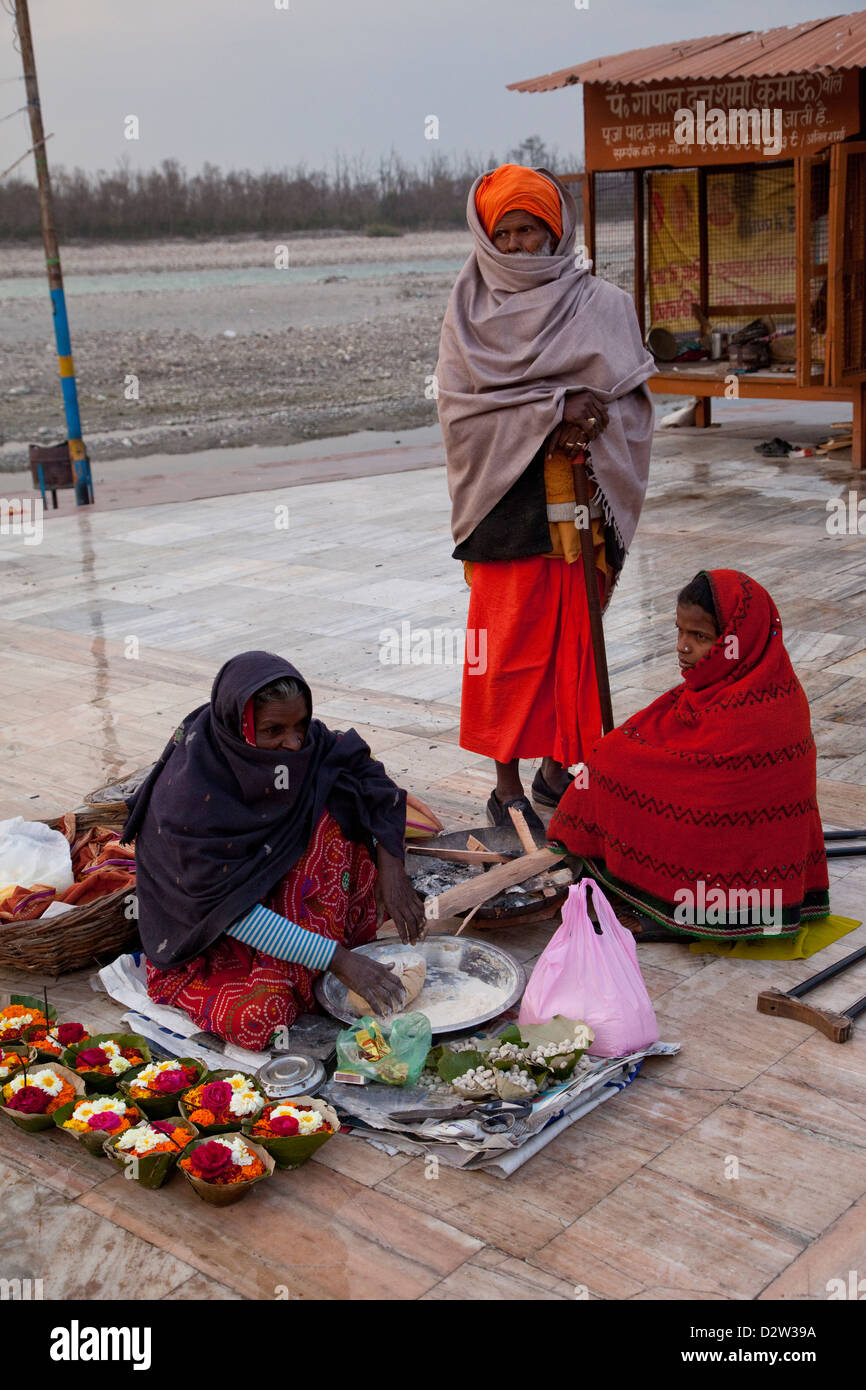 India, Rishikesh. La donna la preparazione di offerte di fiori e farina per  i pellegrini di utilizzare sul Fiume Gange (ganga), in background Foto  stock - Alamy
