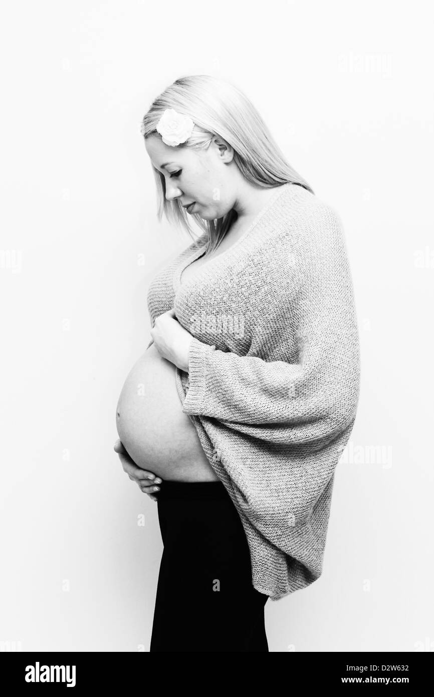 Immagine in bianco e nero della donna incinta mentre tiene il suo stomaco Foto Stock