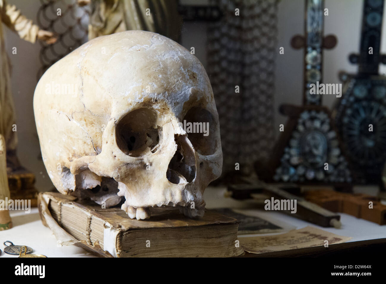 Cranio su un libro presso il Royal Certosa (Real Cartuja), Valldemossa, Maiorca, Spagna. Foto Stock