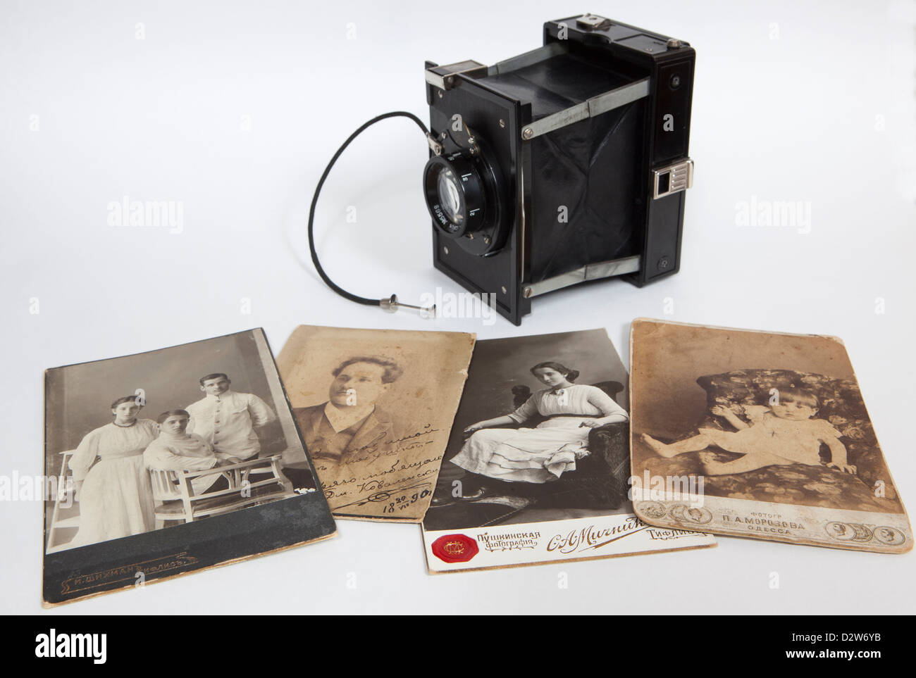 Un antico fotocamera con vecchie foto su sfondo bianco Foto Stock
