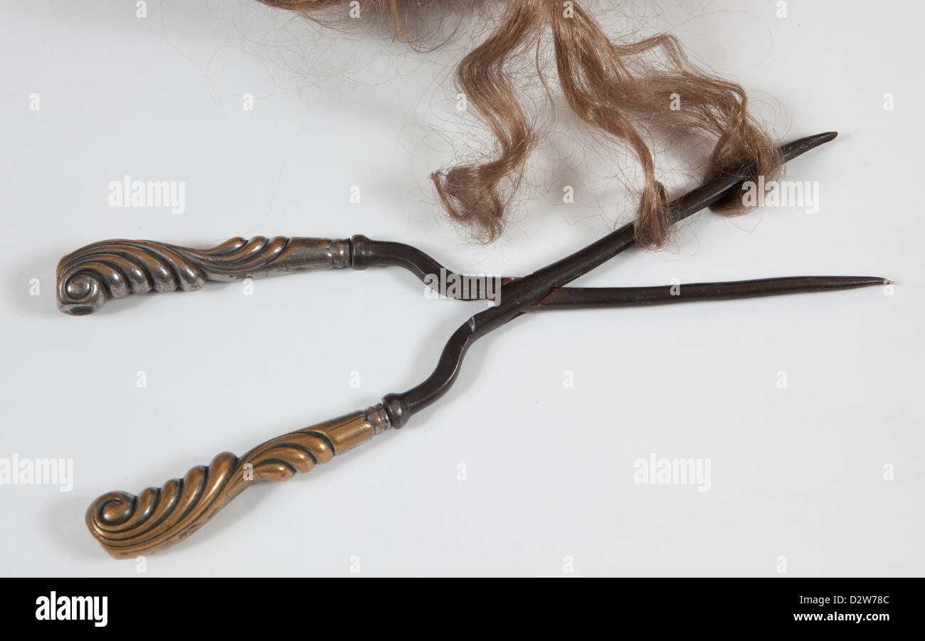 Un antico ferro arricciacapelli con i capelli Foto stock - Alamy