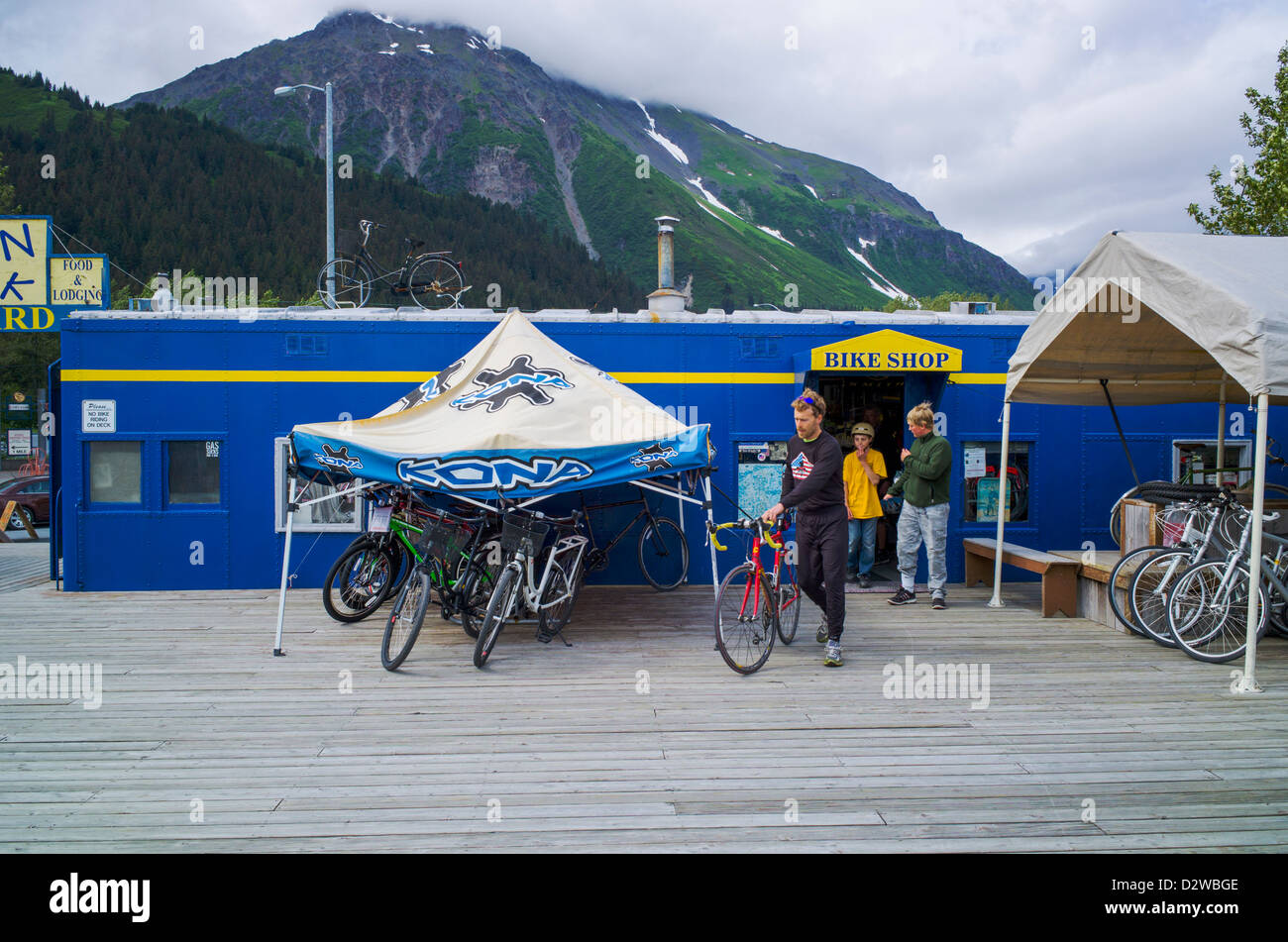 I turisti noleggiare bici. Il treno relitto, raccolta di automotrici ricondizionato da Alaska Railroad ora la casa di fumo cafe Shop Foto Stock