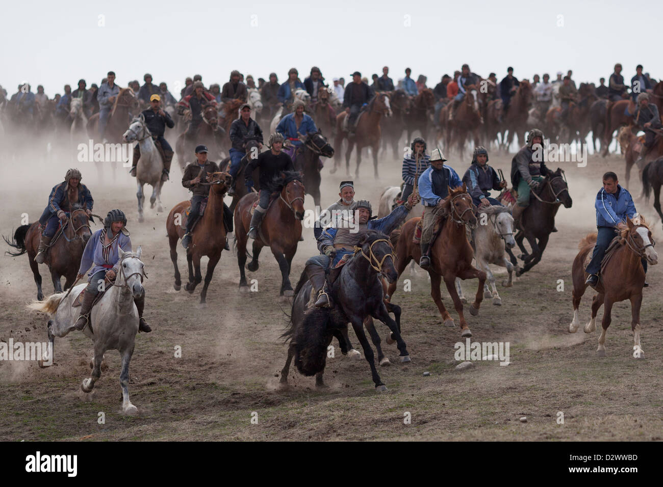 Buzkashi piloti in lotta per il possesso di buz (capra carcassa) in un campo vicino a Dushanbe durante una celebrazione Navruz. Foto Stock