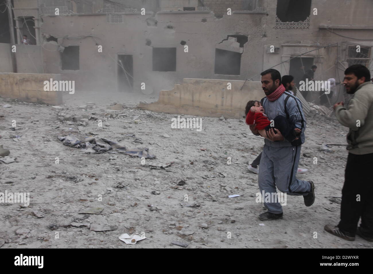 Un uomo detiene un bambino nelle braccia di Aleppo, Siria, 03 febbraio 2013. Un airstrike domenica ha distrutto una casa e ha ucciso e ferito diverse persone. Foto: THOMAS RASSLOFF Foto Stock