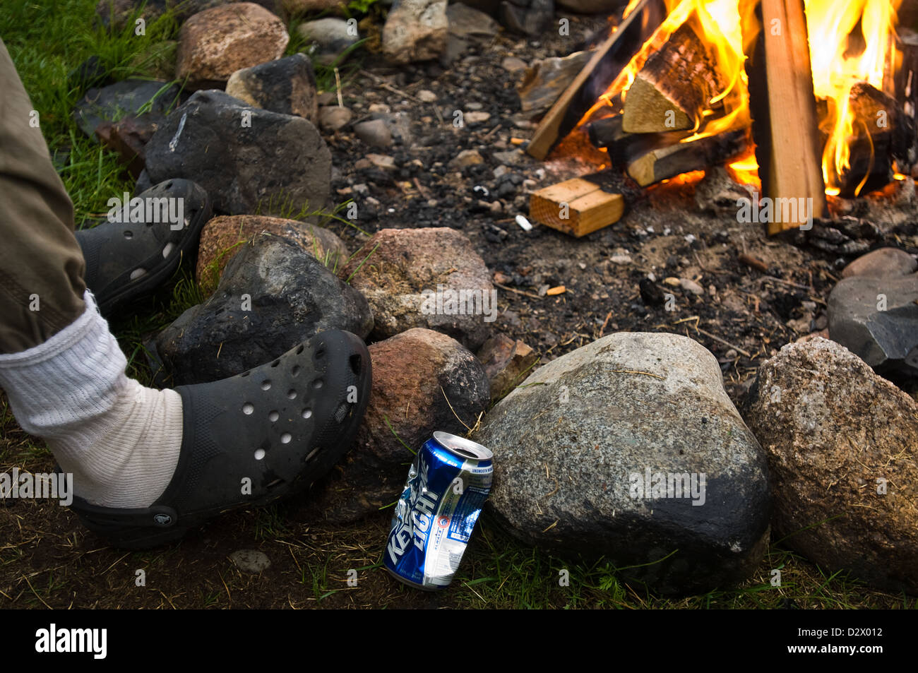Alaska guida di pesca a bere birra accanto al fuoco dopo il lavoro Foto Stock
