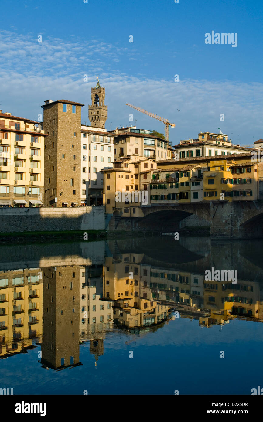 Firenze, Toscana, il Palazzo Vecchio e il Ponte Vecchio e le vostre riflessioni sul fiume Arno con cielo blu Foto Stock