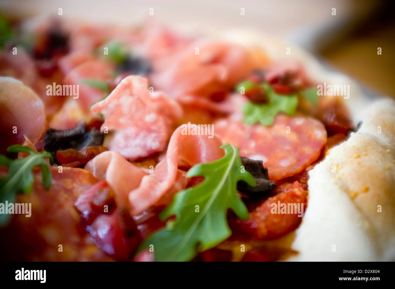 Pizza Anti Pasti, Margherita drappeggiati con salumi roquito, peperoni, olive e vestito razzo. Accompagnare con un bicchiere di vino. Foto Stock