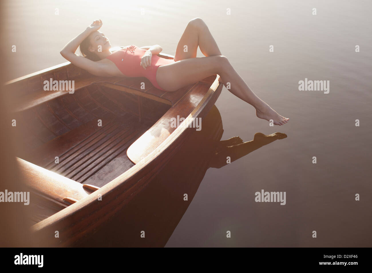 Serena donna a prendere il sole in barca sul lago Foto Stock