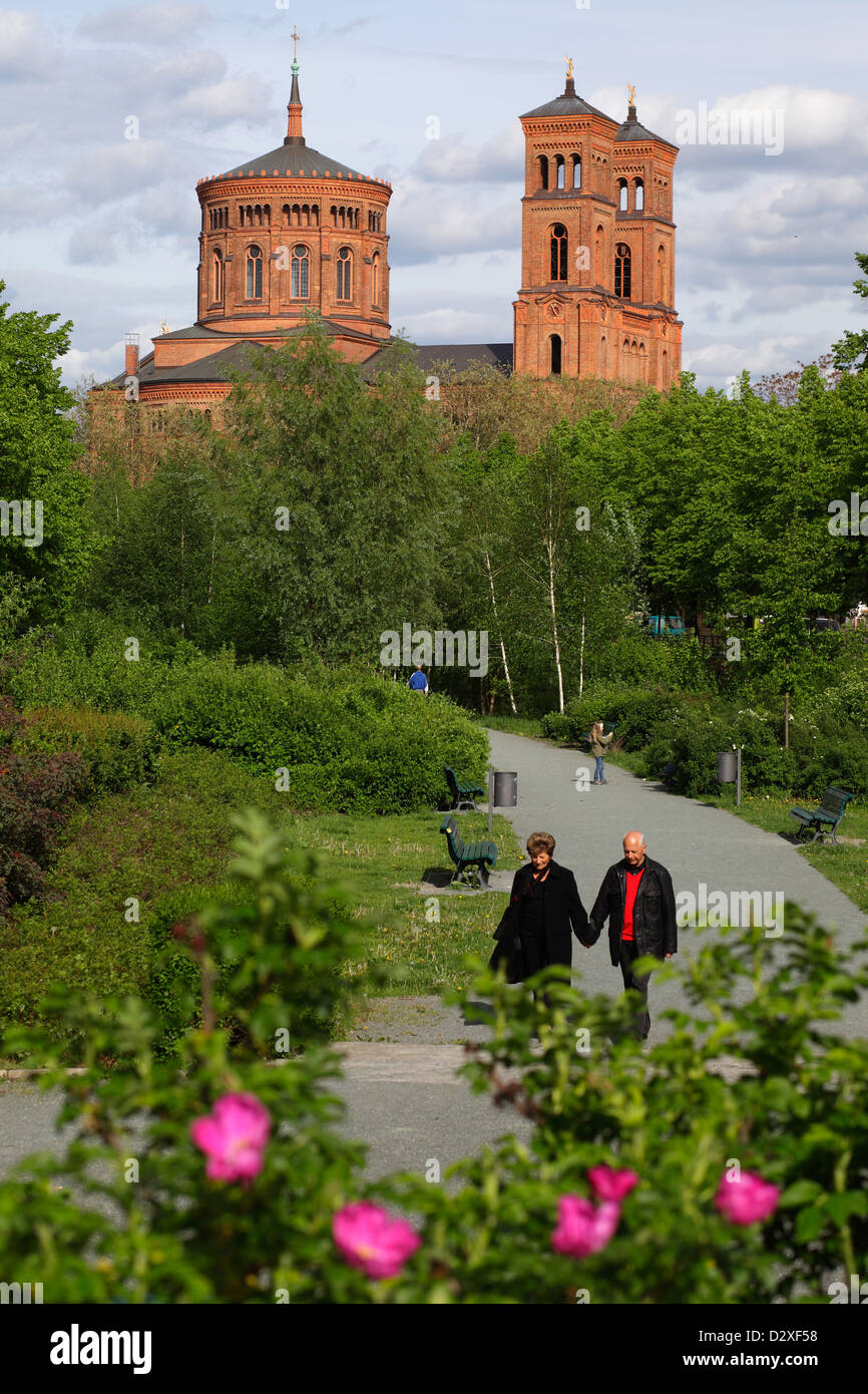Berlino, Germania, i pedoni a camminare in un parco, dietro la chiesa di San Tommaso Chiesa Foto Stock
