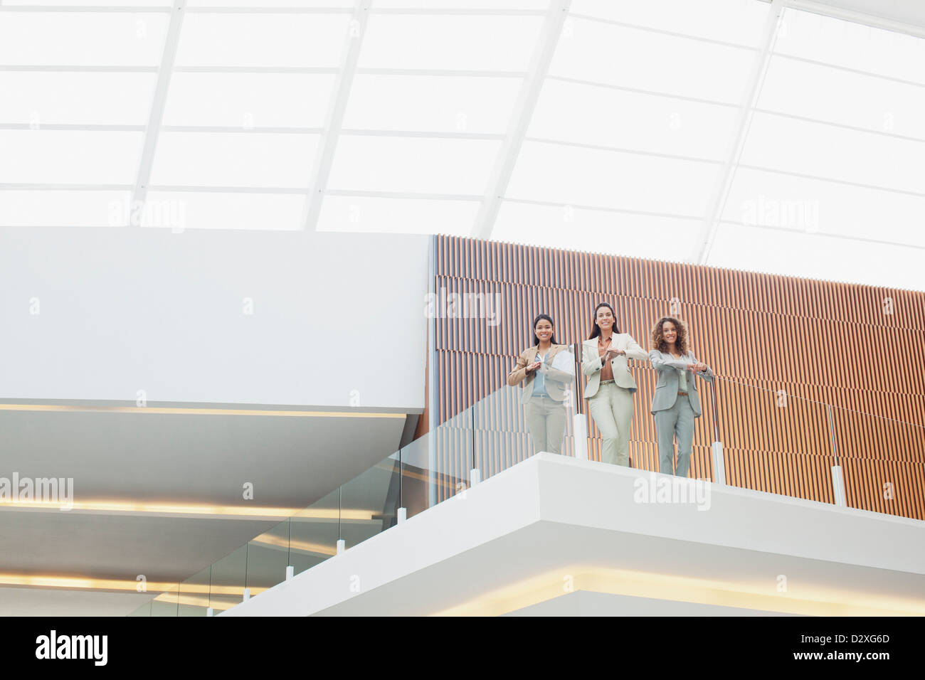 Ritratto di sorridere imprenditrici in piedi sul balcone in ufficio moderno Foto Stock