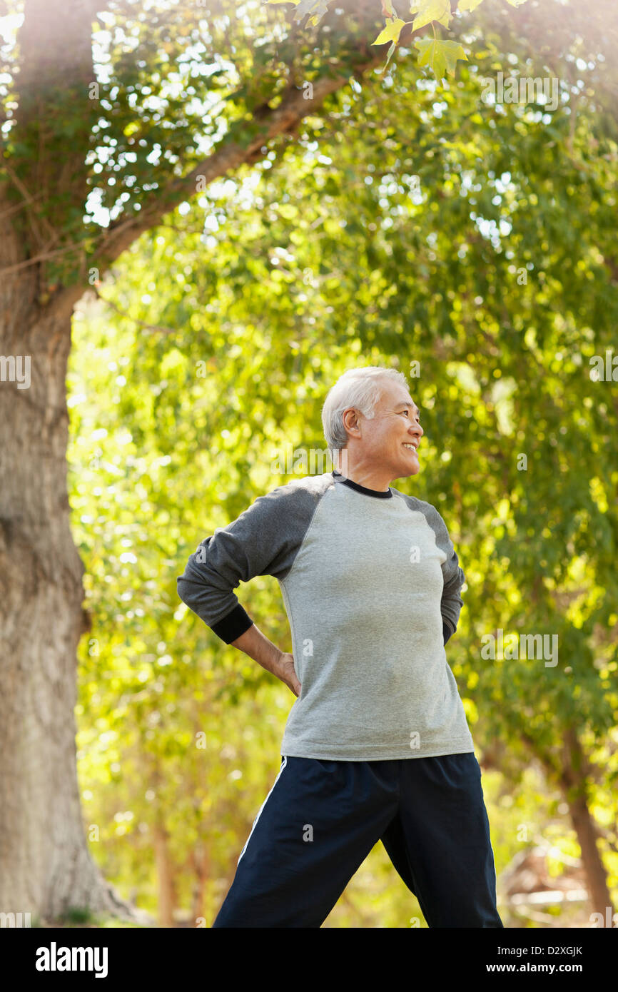 Uomo anziano stretching all'aperto Foto Stock