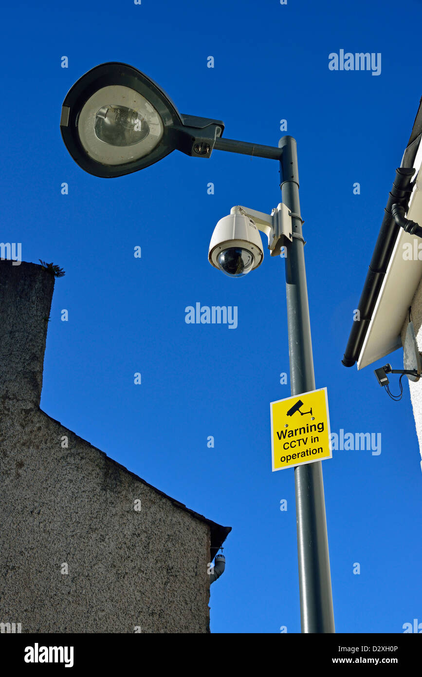 'Avvertimento CCTV in funzionamento'. Avviso e fotocamera su colonna di illuminazione. Foto Stock