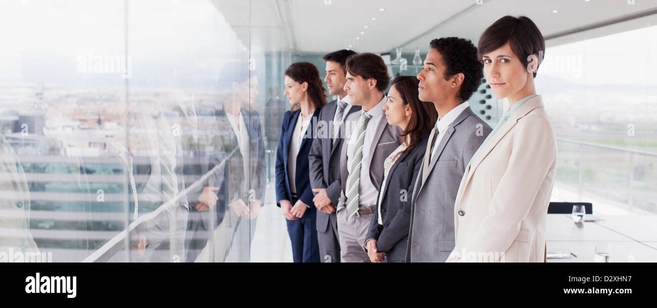 La gente di affari nella sala conferenze a guardare fuori dalla finestra Foto Stock