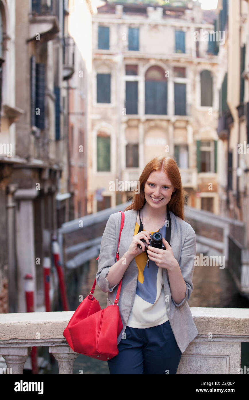 Ritratto di donna sorridente con la fotocamera a Venezia Foto Stock