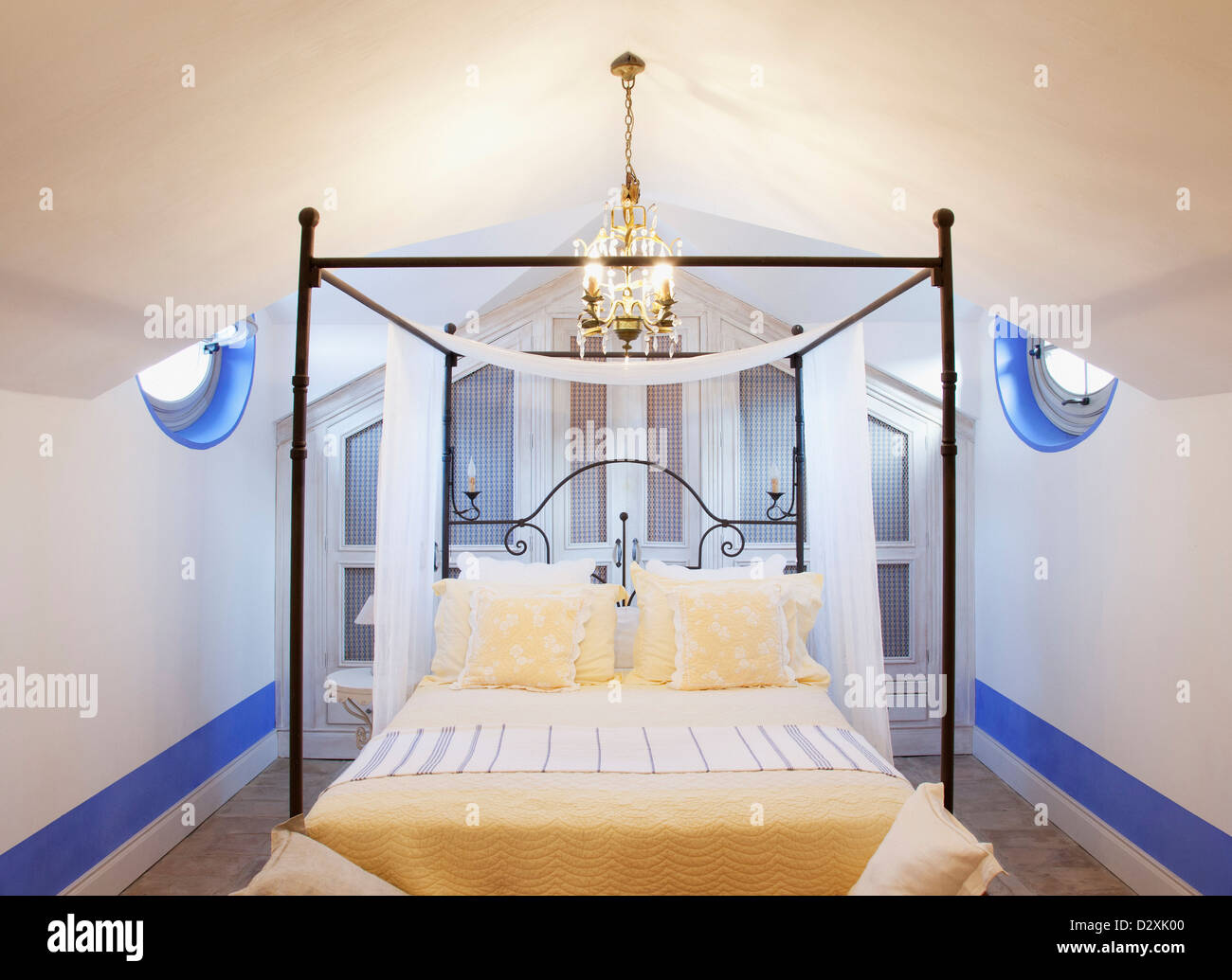 Lampadario sopra il letto a baldacchino in camera da letto di lusso Foto Stock