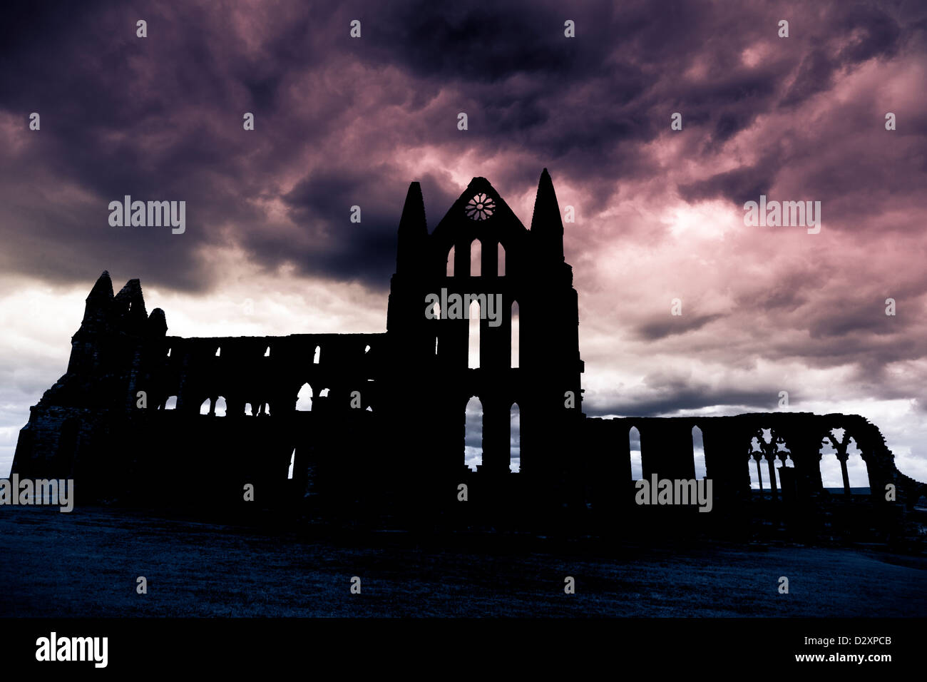 Una silhouette di Whitby Abbey con nuvole scure, nello Yorkshire, Inghilterra Foto Stock