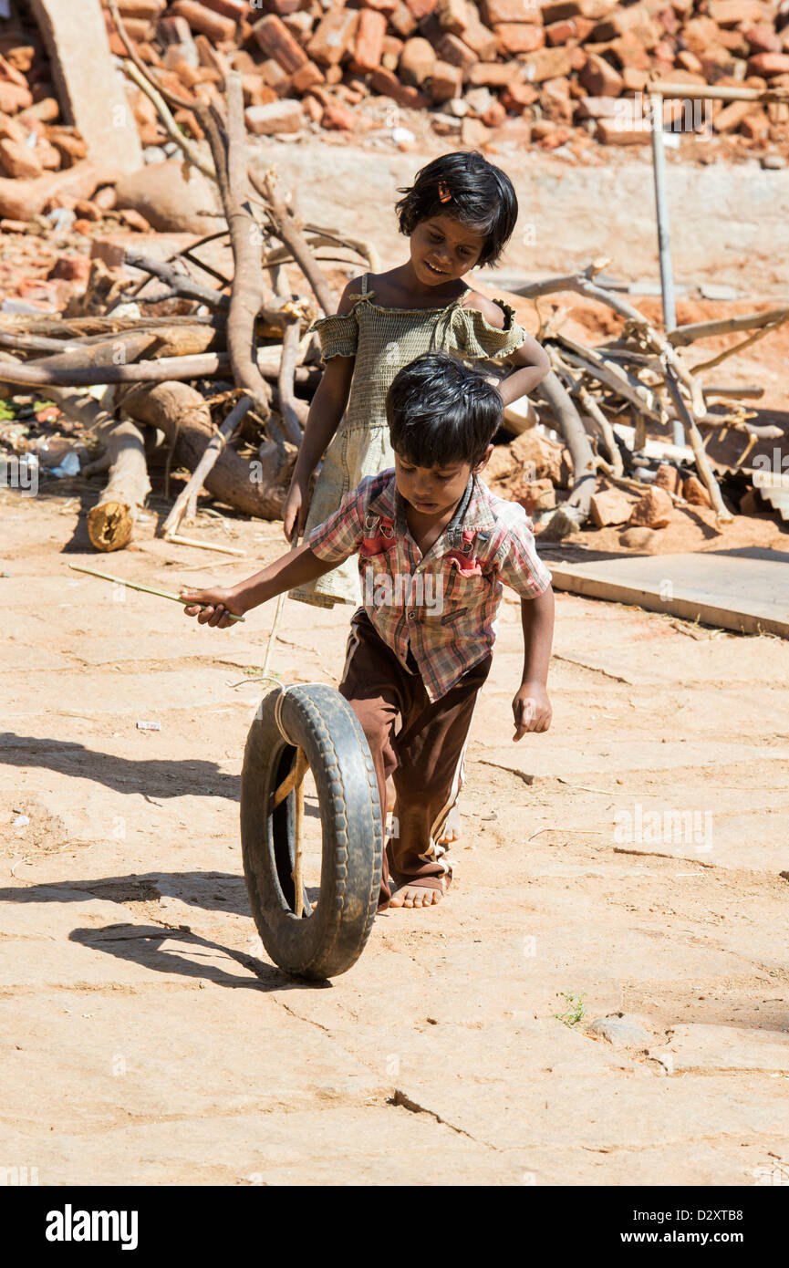 Indian i bambini giocando con un pneumatico in una zona rurale villaggio indiano. Andhra Pradesh, India Foto Stock