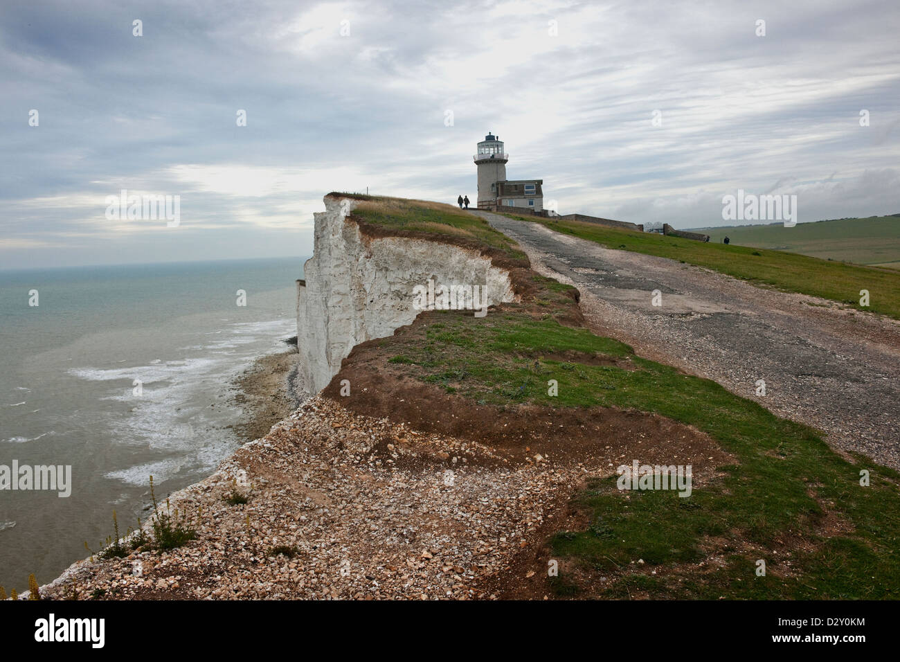 Belle Tout faro al tramonto con un uomo e una donna si avvicina all'orizzonte.nel tardo pomeriggio in East Sussex England Regno Unito Foto Stock